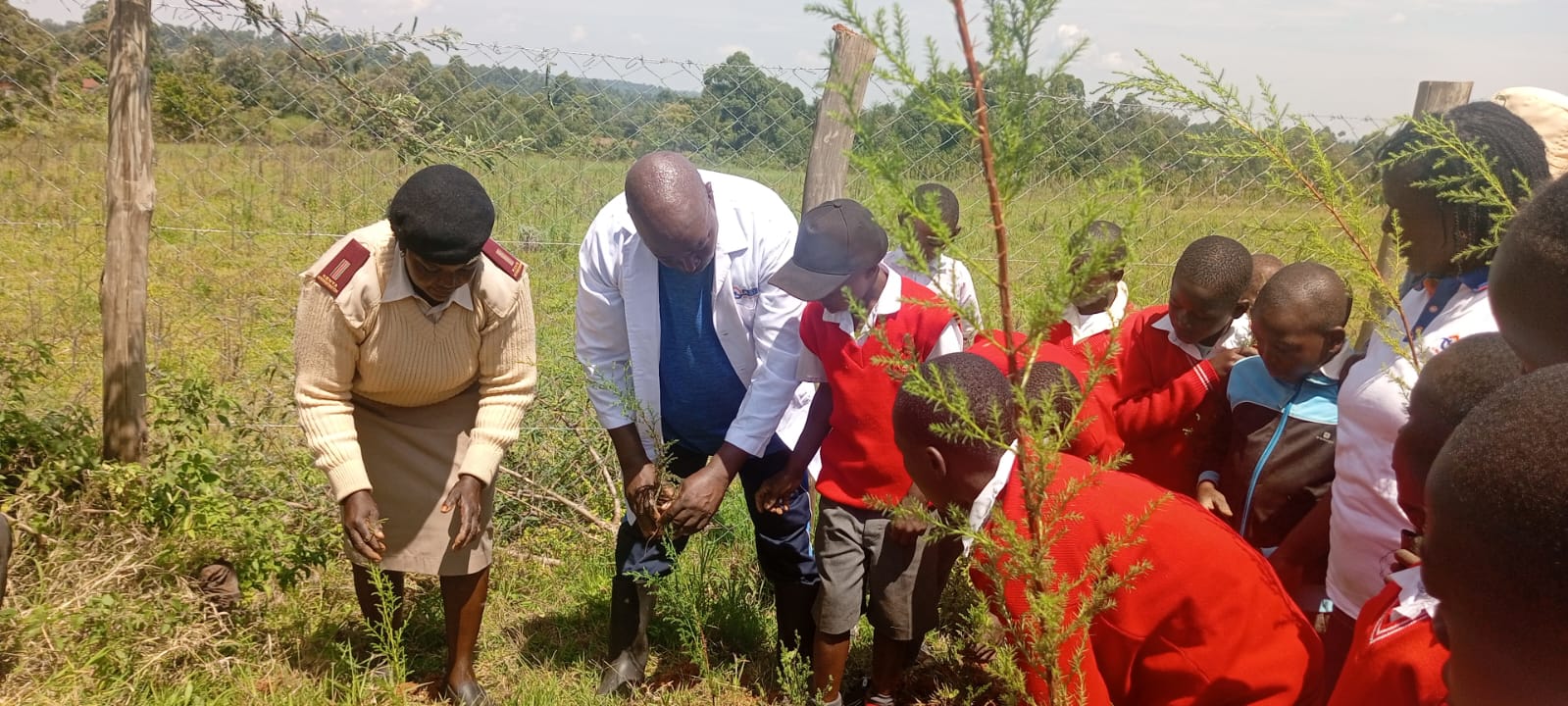 Photo: Zeituni Rashida (Left), Senior Assistant Chief, and Institute’s Joshua Nyakundi (2nd Left) and Jane Nyamwamu (Partly hidden) are joined by pupils of Chepkoiyo Comprehensive School in planting trees around the School’s compound